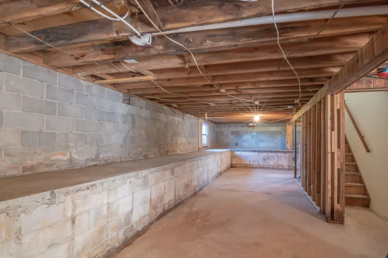 Unausgebauter Keller mit Holzdecke und Betonwänden