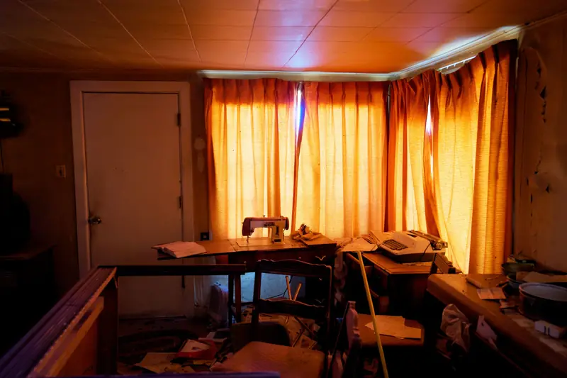 Vollgestelltes Zimmer mit Nähmaschine und Stapeln