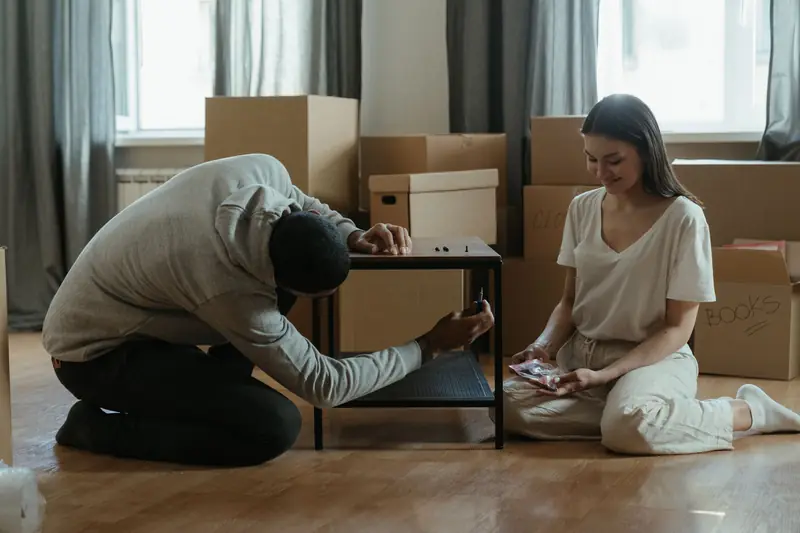 Möbelaufbau im Wohnzimmer zwischen Umzugskartons