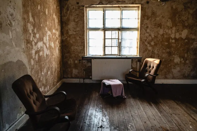 Altes Zimmer mit zwei Sesseln unter dem Fenster