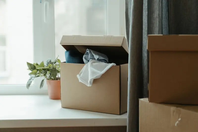 Gepackter Karton am Fenster einer geräumten Wohnung