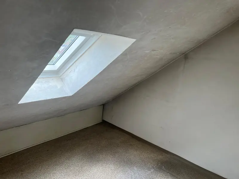 Leerer Dachraum mit Dachfenster nach der Räumung