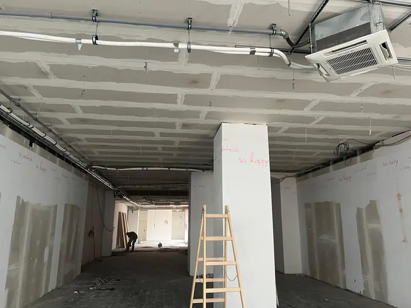 Dieselbe Ladenfläche nach Rückbau der Decke, Leitungen freigelegt