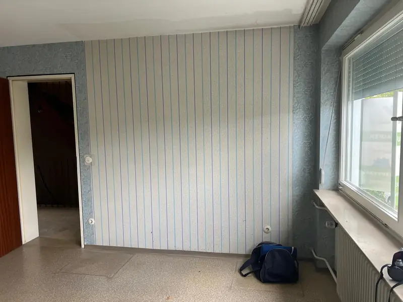 Geräumtes Zimmer mit gestreifter Tapete