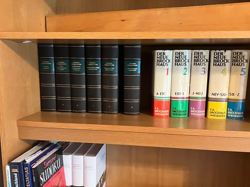 Regal voller Lexika und Bücher