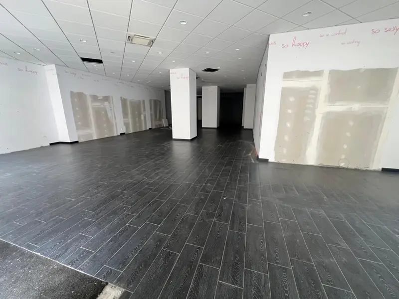 Ladenfläche mit abgehängter Rasterdecke vor dem Rückbau